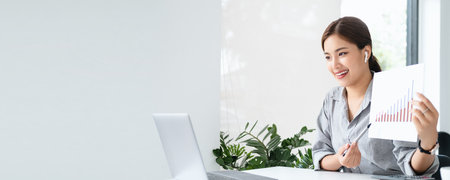 business woman talking about sale report in video conference. Asian team using laptop and tablet online meeting in video call.Working from home, Working remotely Social isolation. banner copy spaceの写真素材