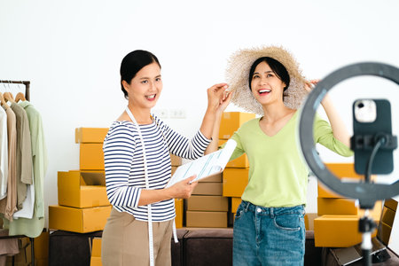 Asian woman selling vintage clothes, she is live on social media.
She is answering customers questions.の写真素材