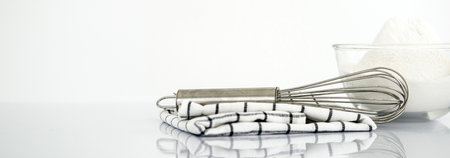 Wide horizontal Panorama cover and header web Banner. Baking concept. Bowl with a whisk and dishcloth on white table over white background with copy space.の写真素材