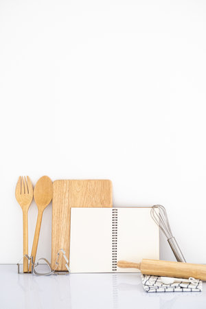 Vertical blank cook book  and wooden kitchen tool on white table and White background. Front view copy spaceの写真素材