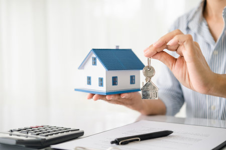 Real estate agent with house model and keysの写真素材