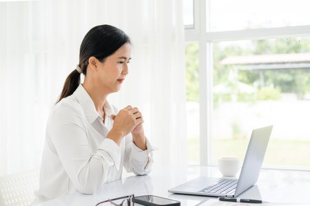 Thinking about how to take the business to technological heights. Smiling attractive cheerful young businesswoman working in modern office.の写真素材