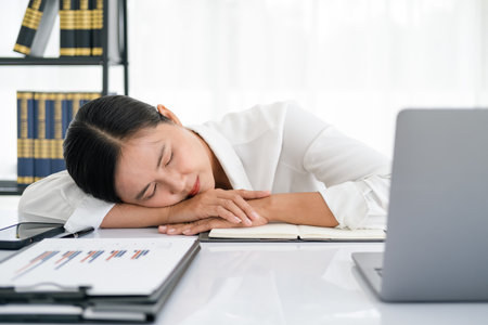 tired business woman sleepy and bored from sitting at a desk for a long time and has office syndromeの写真素材