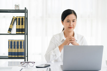Asian young female working on laptop at officeの写真素材