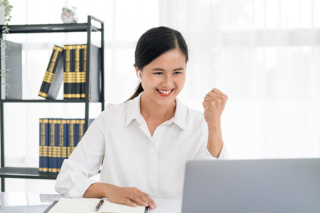 Successful business woman with arms up - isolated over a white office backgroundの写真素材