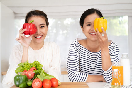 Beautiful girlfriends cooking in the kitchen. Best friends preparing healthy home made meal in the kitchen.の写真素材