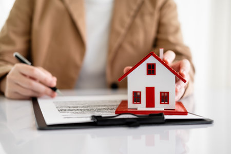 House model with real estate agent and customer discussing for contract to buy house, insurance or loan real estate background.の写真素材