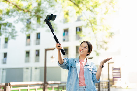 Tourists in the city taking selfies on university street. Asian girl taking selfies while walking on...