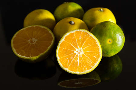 Fresh juicy clementine mandarins isolated on black