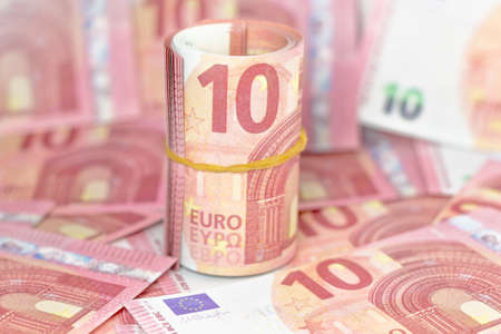 rolled 10 euro with euro backgroundの写真素材