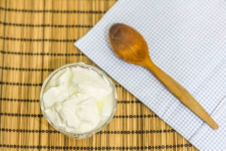 Natural homemade plain organic yogurt with wood spoonの写真素材