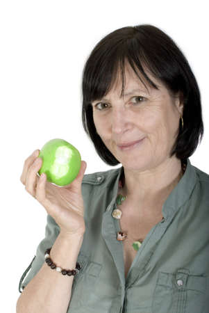 Balanced diet concept shot. Aged woman with fresh apple in her hand.の写真素材