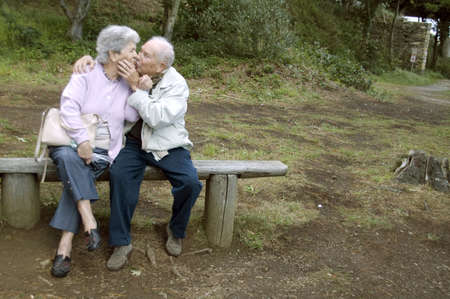 Old happy senior couple sitting on benchの写真素材