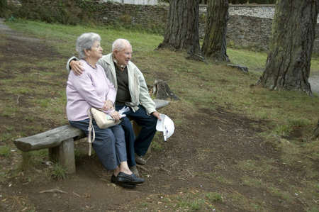 Old happy senior couple sitting on benchの写真素材