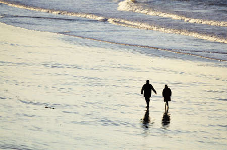 Shot of adult couple walking on the beach of Saint-Malo in brittany, franceの写真素材