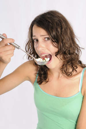 Shot of cute girl with spoon full of pills. Concept shot for alternative medicine