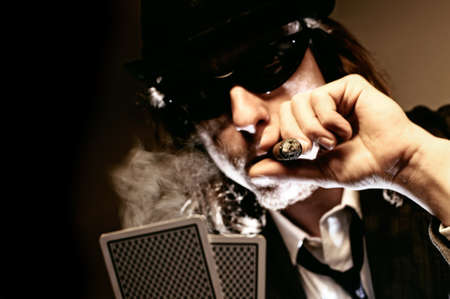Man with hat and cigar playing underground poker.のeditorial素材