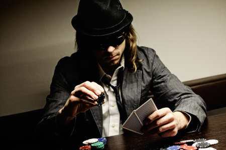 Man with hat and glasses playing underground poker.のeditorial素材