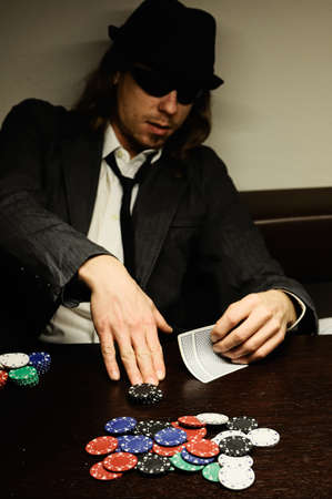 Man with hat and glasses playing underground poker.のeditorial素材