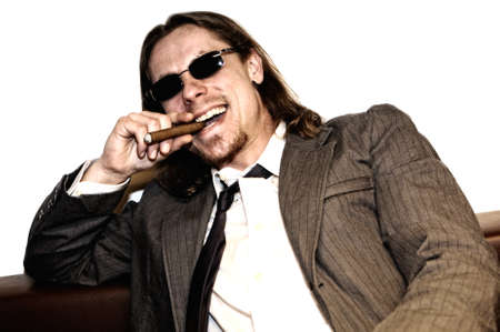 Successful businessman laughing and smoking cigarの写真素材