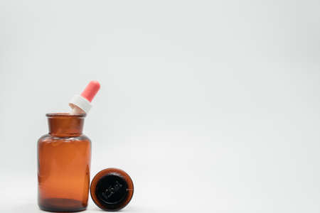 Amber glass bottle and plastic dropper on white backgroundの写真素材