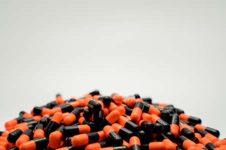 Orange, black, capsule pills on white backgroundの写真素材