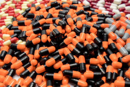 Orange, black, grey, white, red, pale yellow, capsule pillsの写真素材