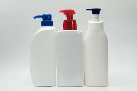 Three white bottles with red and blue pumpの写真素材