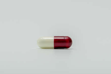 White, red capsule pills isolated on white backgroundの写真素材