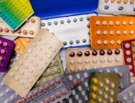 Piles of colorful birth control pills with modern packagingの写真素材