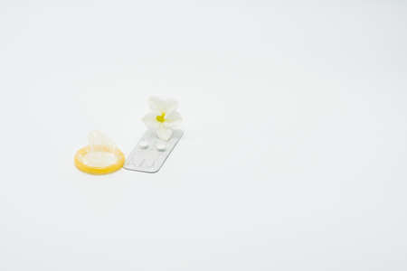 Emergency contraceptive pills, condom and flower on white backgroundの写真素材