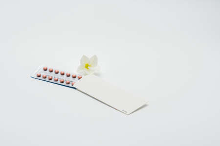Birth control pills with flower in white backgroundの写真素材