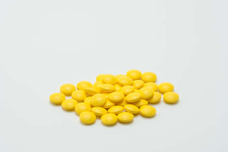 Yellow tablet pills on white backgroundの写真素材