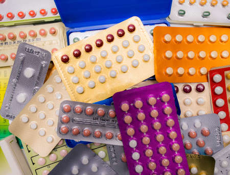 Piles of colorful birth control pills with modern packagingの写真素材