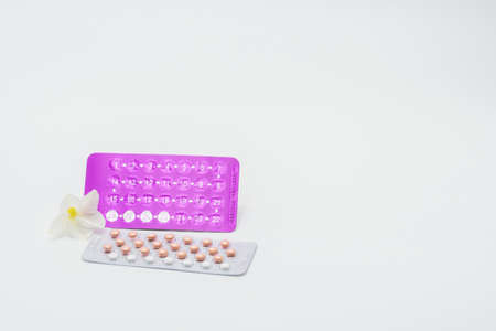 Birth control pills with flower on white backgroundの写真素材