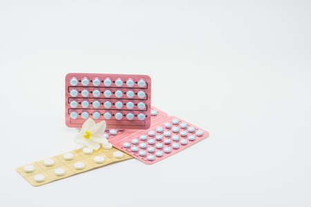 Birth control pills with flower in white backgroundの写真素材
