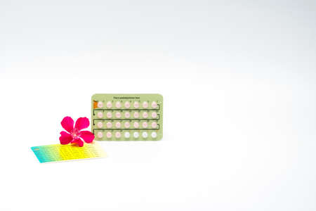 Contraceptive pills with pink flower on white backgroundの写真素材