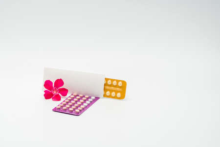 Contraceptive pills with pink flower on white backgroundの写真素材