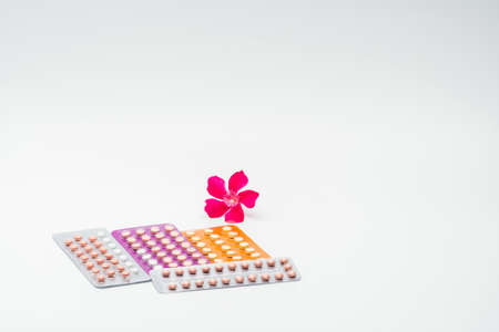 Contraceptive pills with pink flower on white backgroundの写真素材