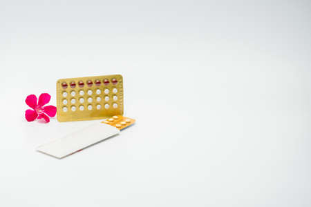Contraceptive pills with pink flower on white backgroundの写真素材