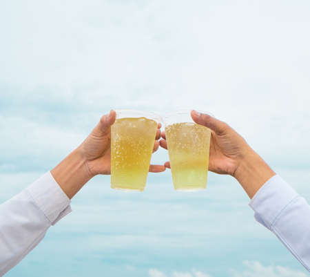 Celebration party, hands hold beverage beers with plastic glasses and cheer for success have...