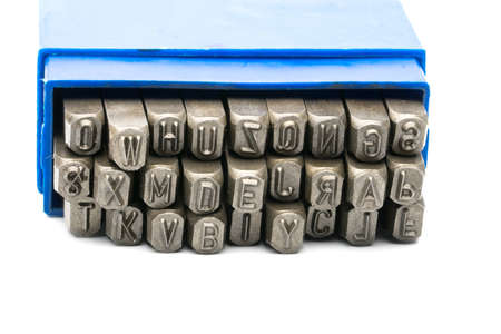 Set of metal stamp alphabet punch in blue plastic box isolated on white backgroundの写真素材