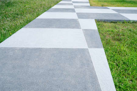 Chess concrete pathway and green grassの写真素材