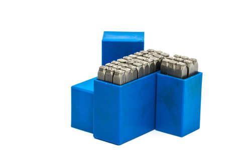 Set of metal stamp alphabet and number punch in blue plastic box isolated on white background with copy spaceの写真素材