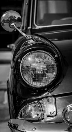 Black and white picture of front view of classic car with headlightの写真素材