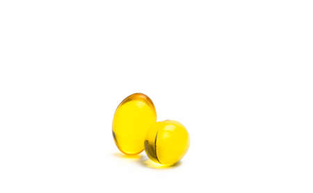 Two capsules of cod liver oil isolated on white background. Source of Omega-3 and vitamin A & D helps growth development and absorption of calcium and phosphorous in the body, just add your own textの写真素材