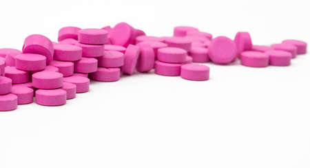 Pile of pink tablets pills isolated on white background with clipping path. Copy spaceの写真素材