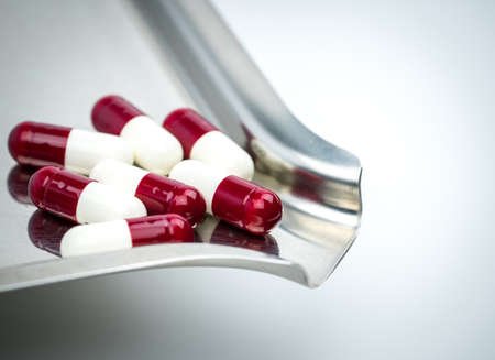Colorful of antibiotic capsules pills with shadows on stainless steel drug tray, drug resistance concept.の写真素材