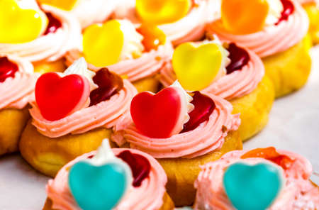Donuts stuffed with whipped cream and topping with heart shaped jelly and jamの写真素材