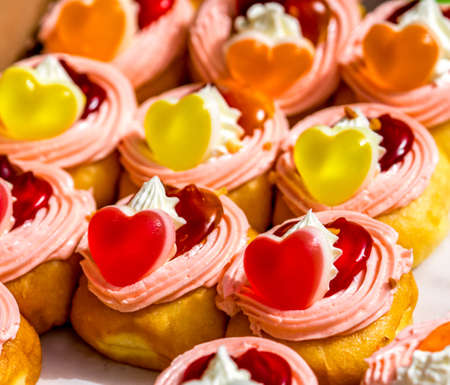 Donuts stuffed with whipped cream and topping with heart shaped jelly and jamの写真素材